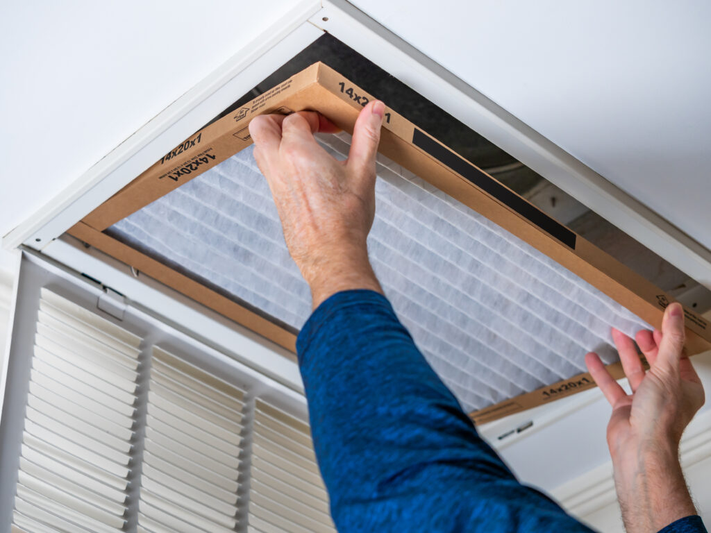 HVAC technician replacing a home air filter in Compton